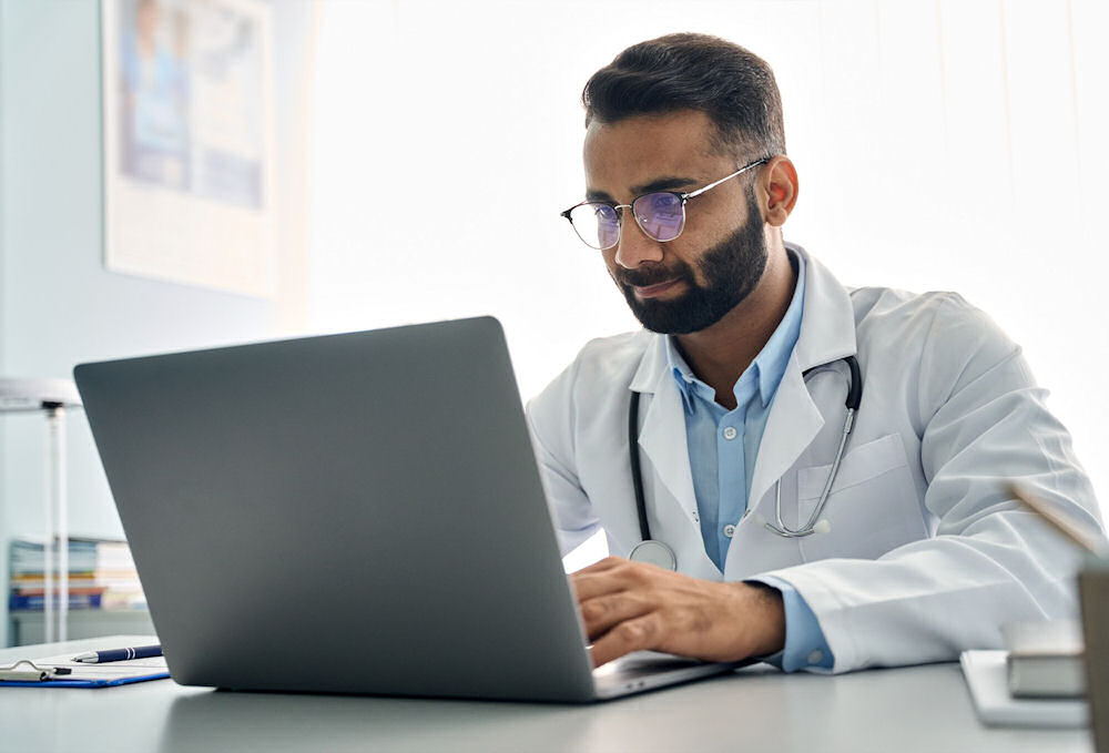 health expert typing on laptop during telehealth